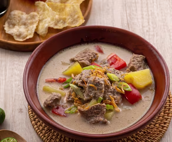 Semangkuk Soto Betawi lezat kaya rempah dengan irisan daging dan emping